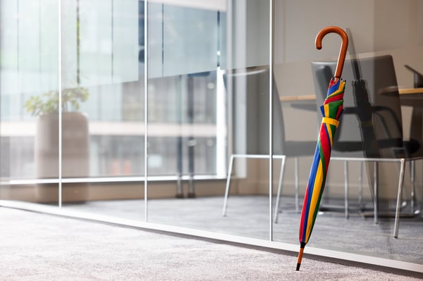 Image of the L&G branded umbrella leaning against an office door