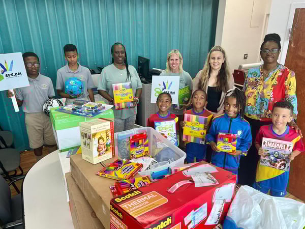 School children surrounded by donation of school supplies